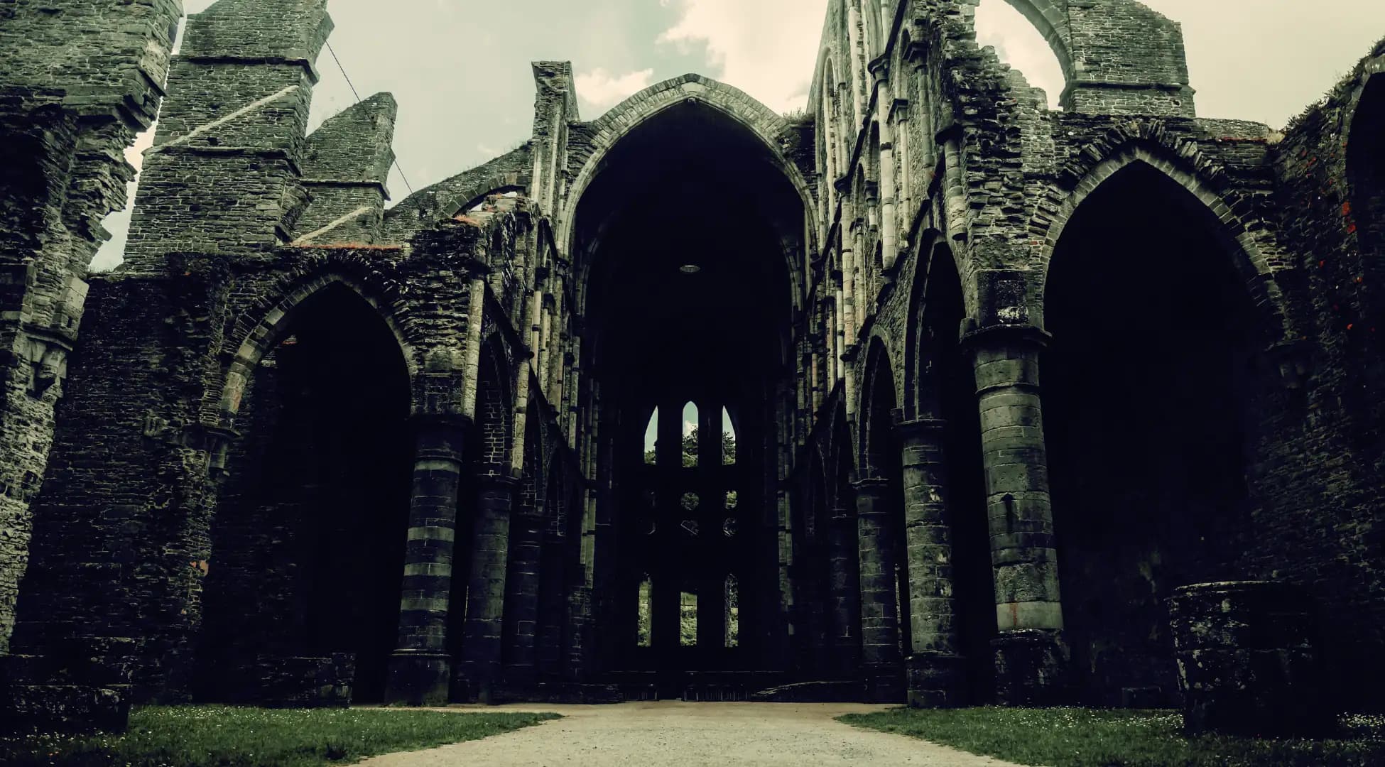 Ruines mystérieuses d'une abbaye gothique en Belgique, invitant à l'exploration et à l'aventure avec Pop'in.