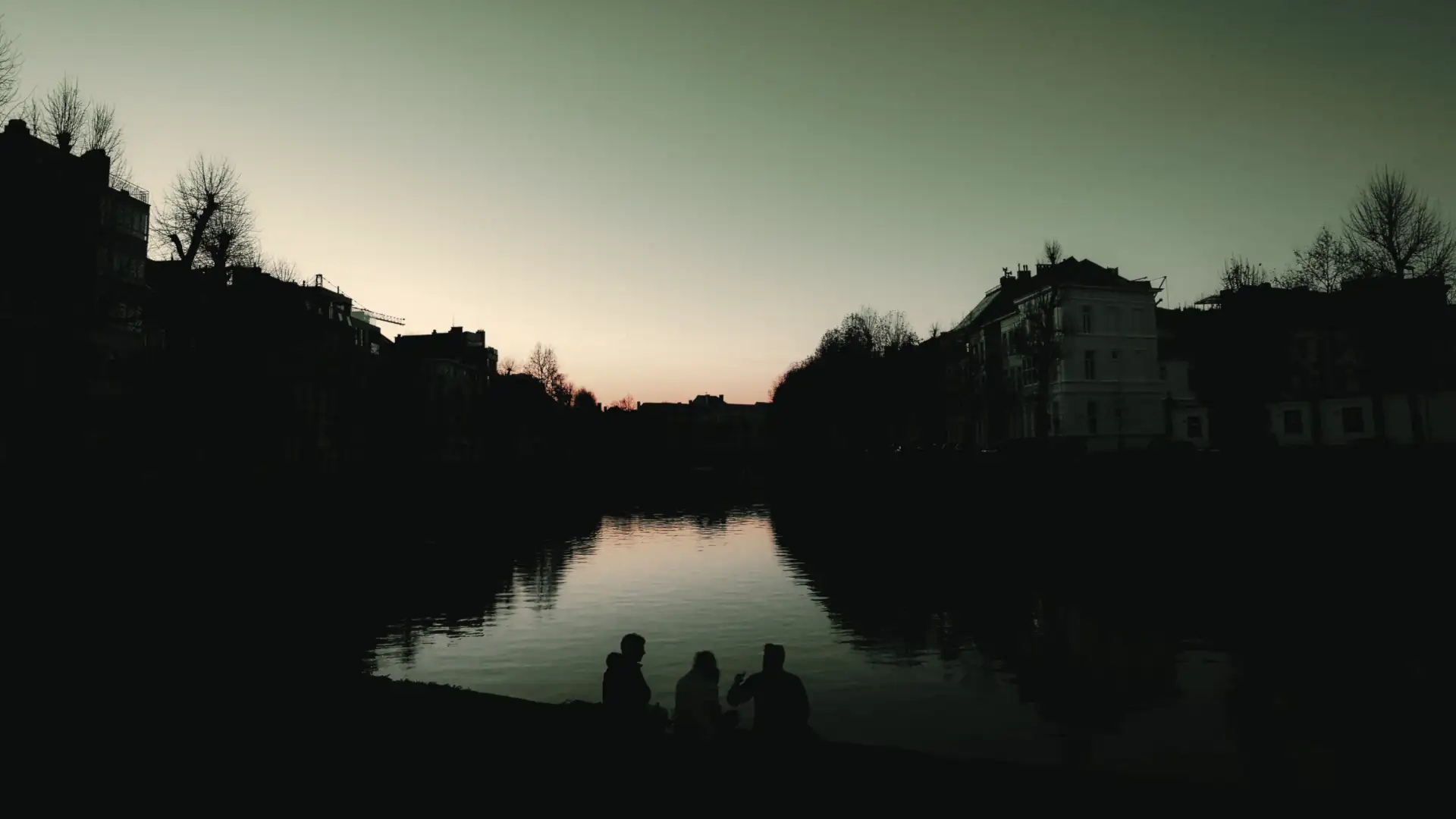 Trois amis profitant d'une escapade surprise personnalisée au coucher du soleil en Belgique avec Pop'in, découvrant des paysages uniques et des expériences mémorables.