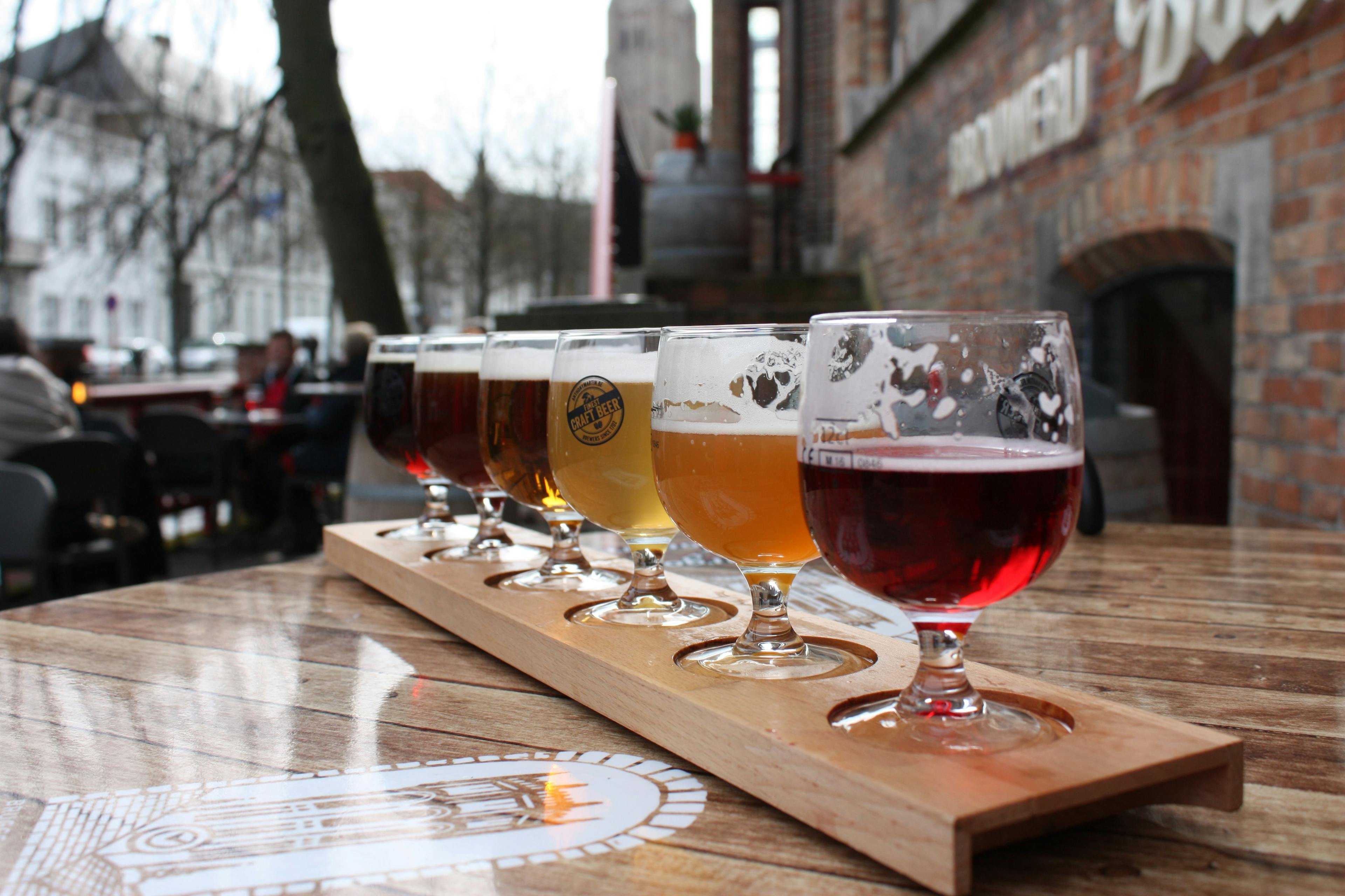 Dégustation de bières belges artisanales, comme les Duvel, sur une table, illustrant l'expérience culinaire unique offerte par Pop'in.