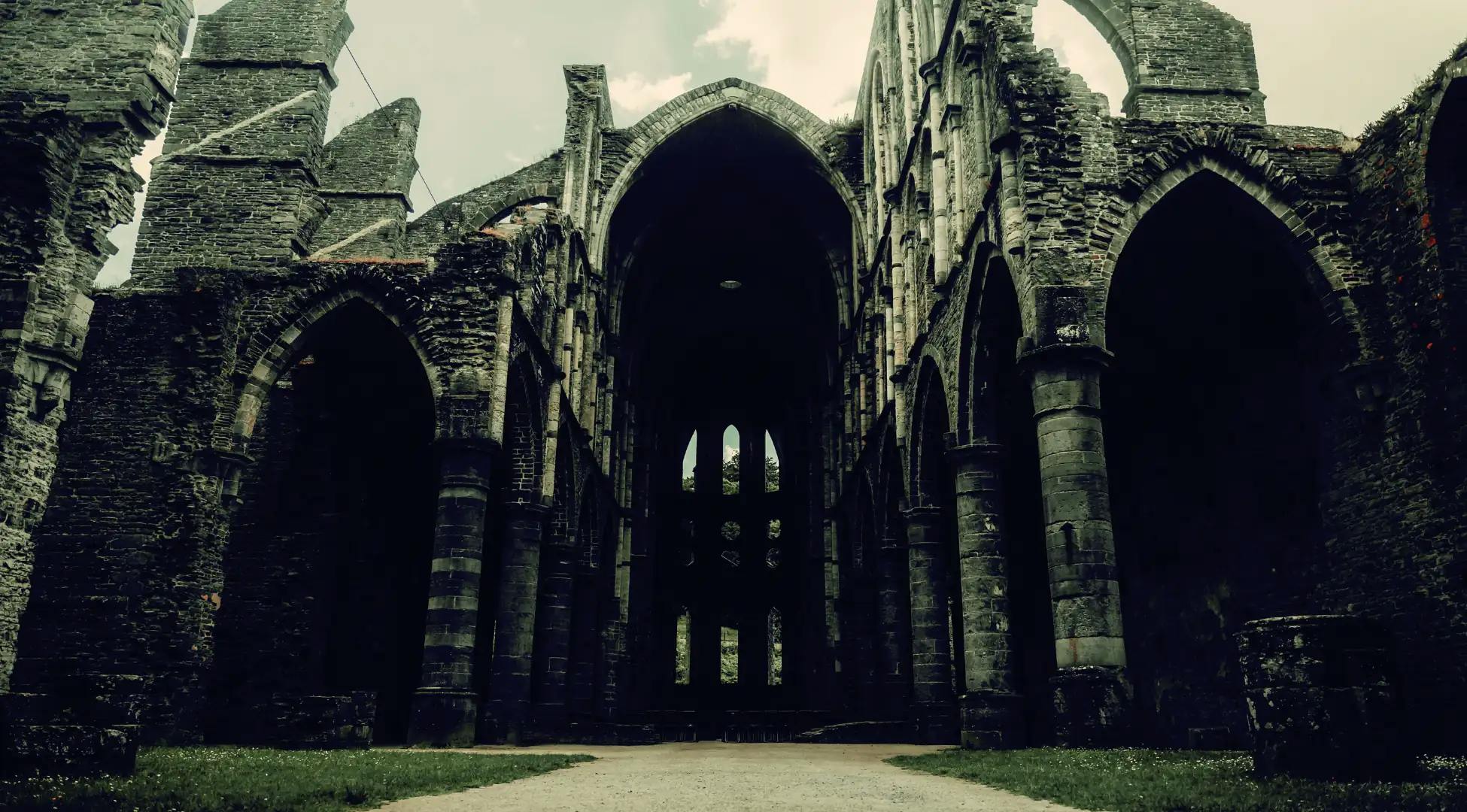 Ruines mystérieuses d'une abbaye gothique en Belgique, invitant à l'exploration et à l'aventure avec Pop'in.