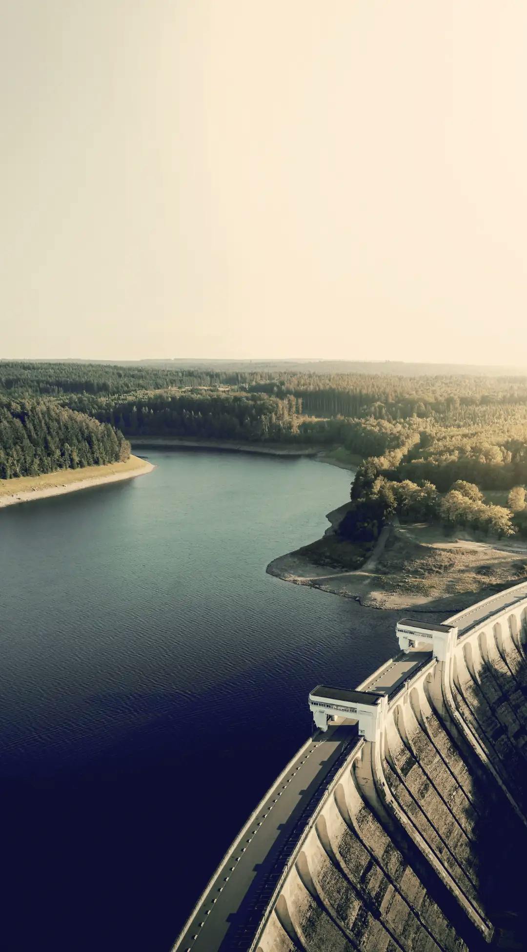 Vue pittoresque d'un barrage avec lac et forêt, illustrant les escapades tranquilles offertes par Pop'in.