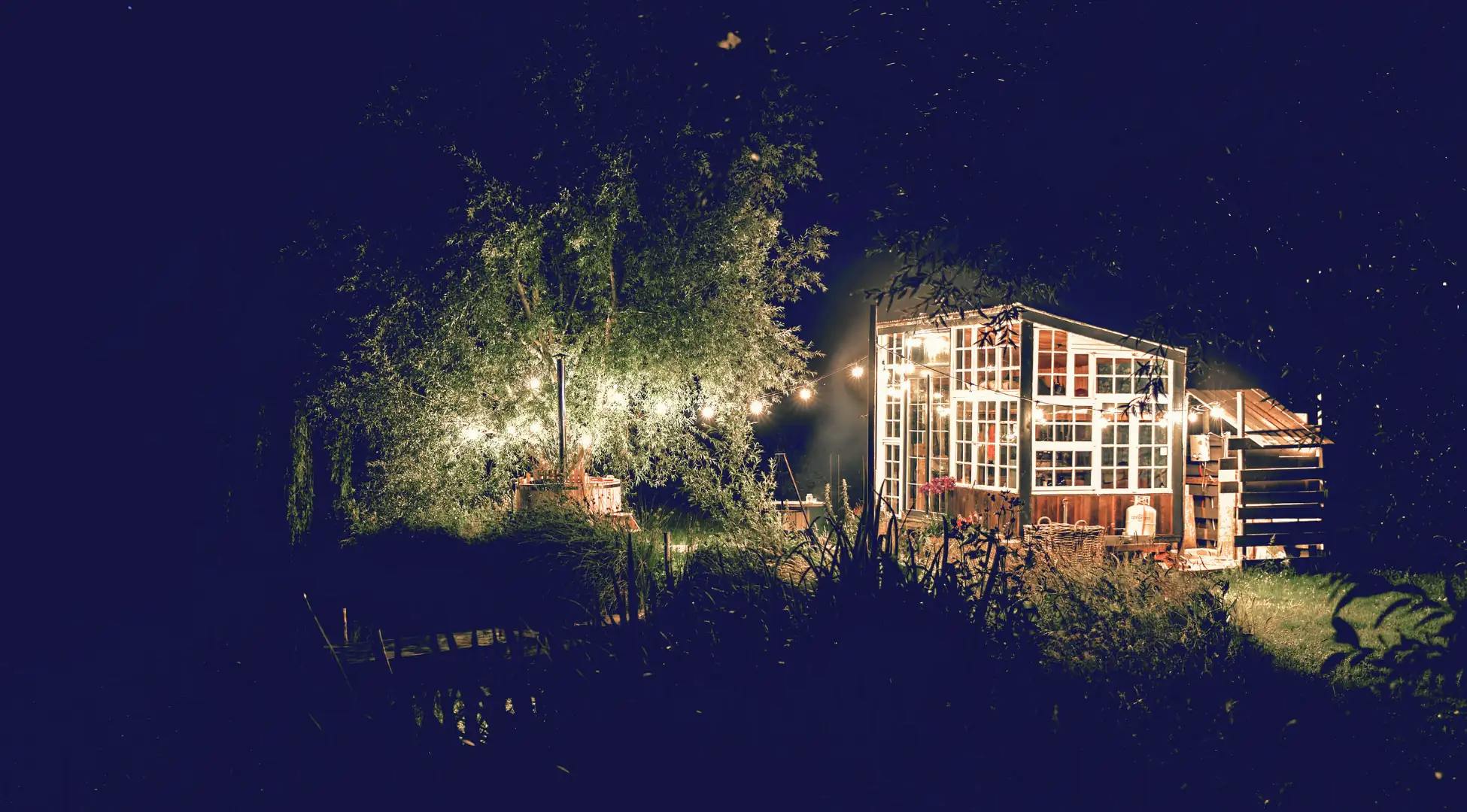 Cabane luxueuse illuminée la nuit, un havre de paix pour une retraite exclusive avec Pop'in.